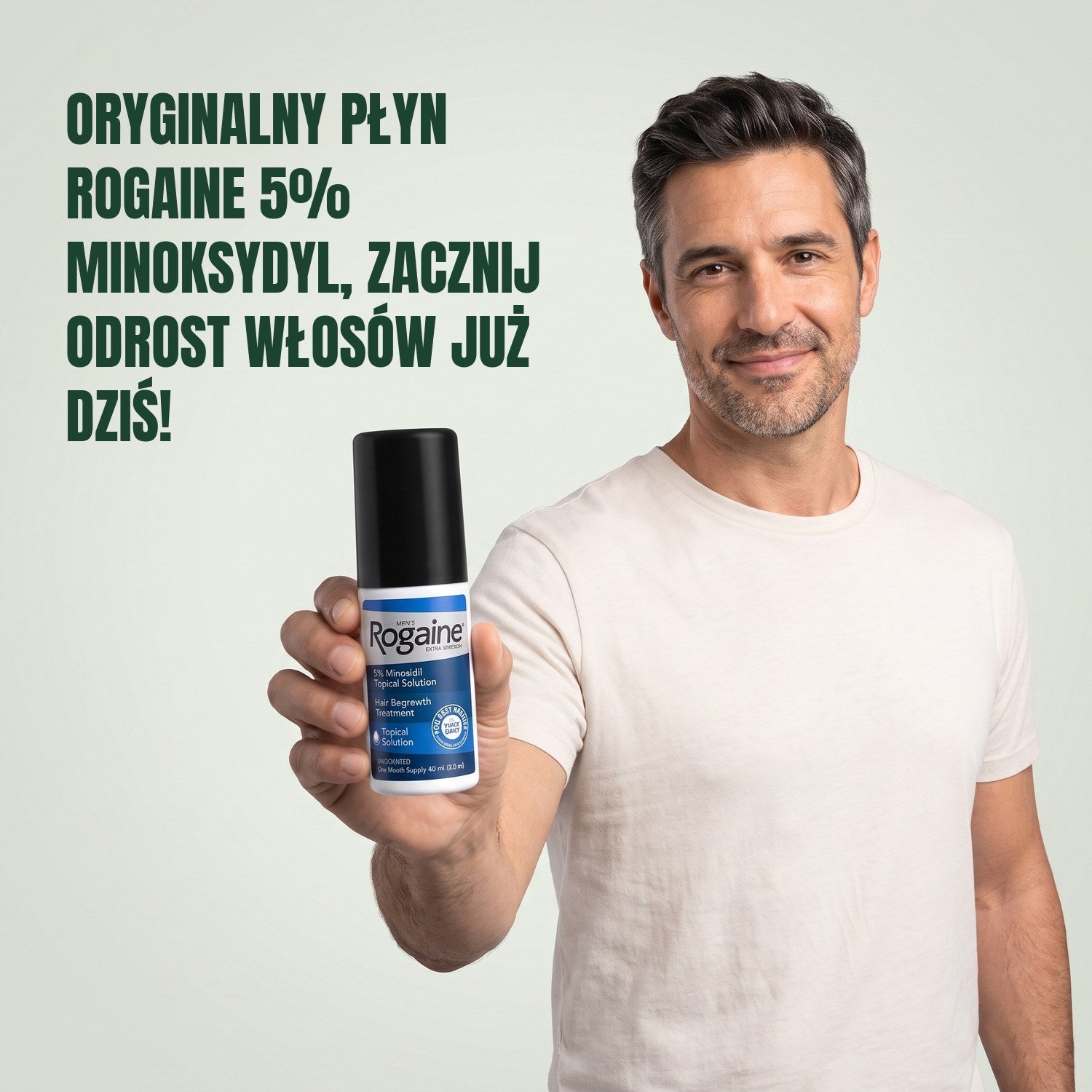 Mężczyzna trzyma butelkę płynu Rogaine 5% minoxidil na tle zielonego tła