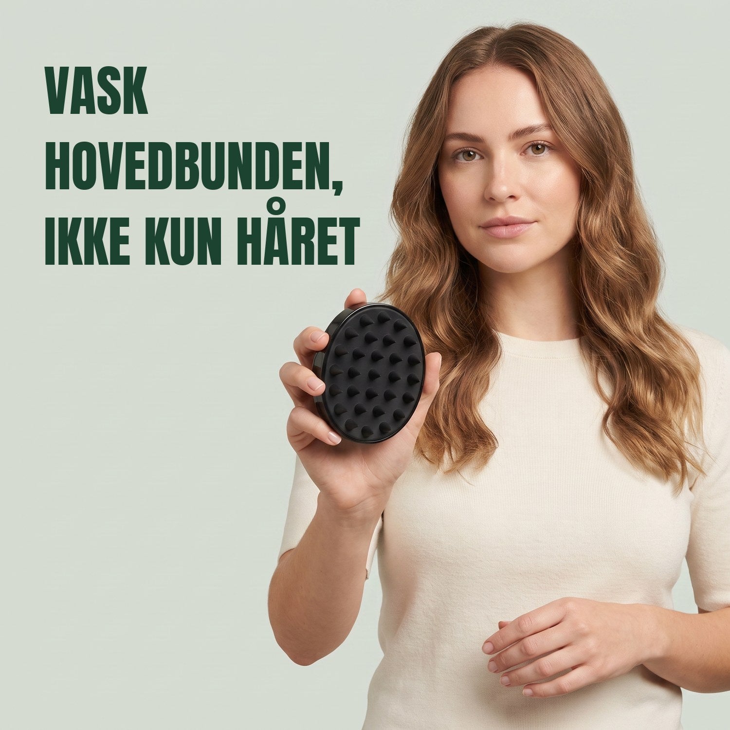 Kvinde holder hovedbundsmassagebørsten mod en grøn baggrund