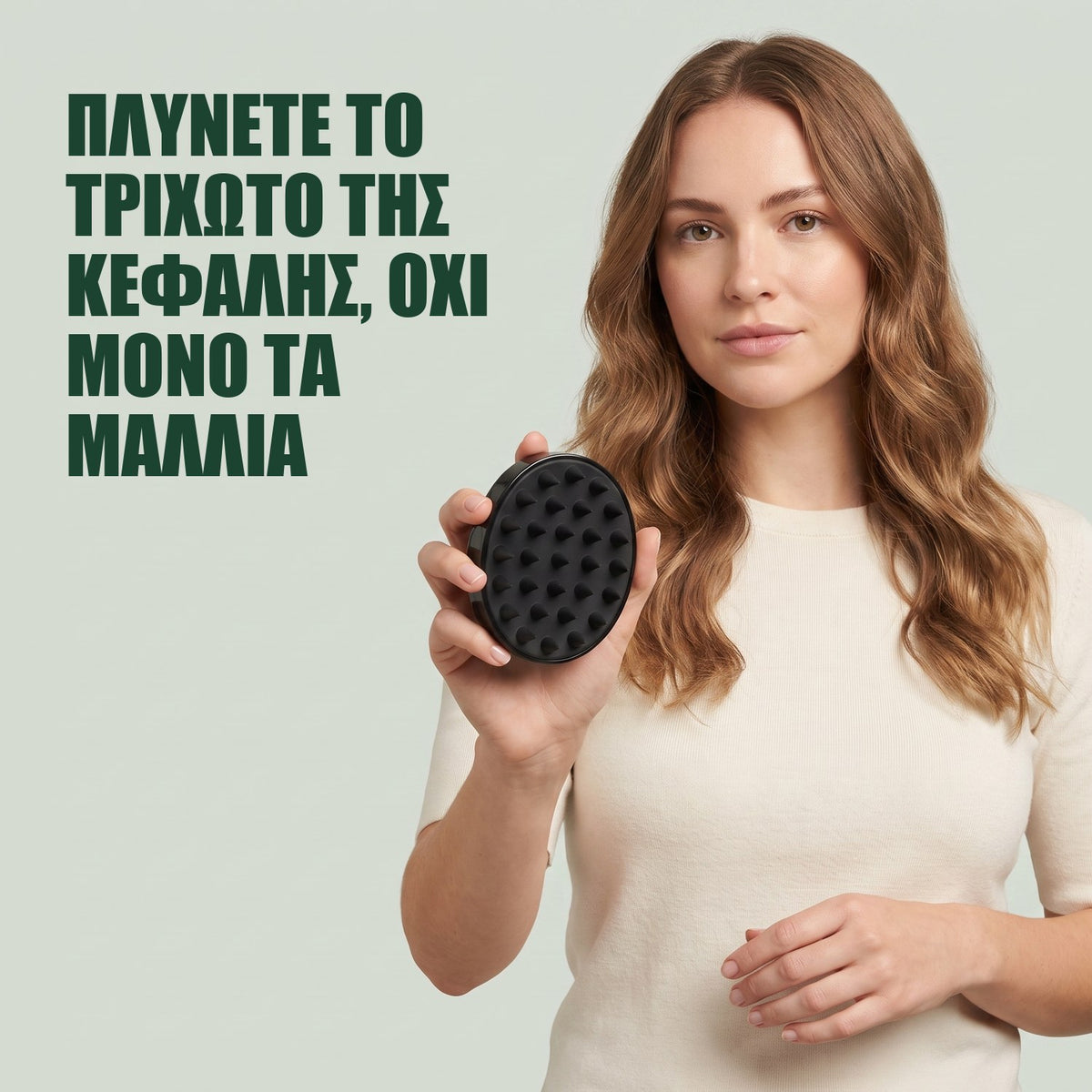 Γυναίκα κρατά τη βούρτσα μασάζ για το τριχωτό της κεφαλής σε πράσινο φόντο