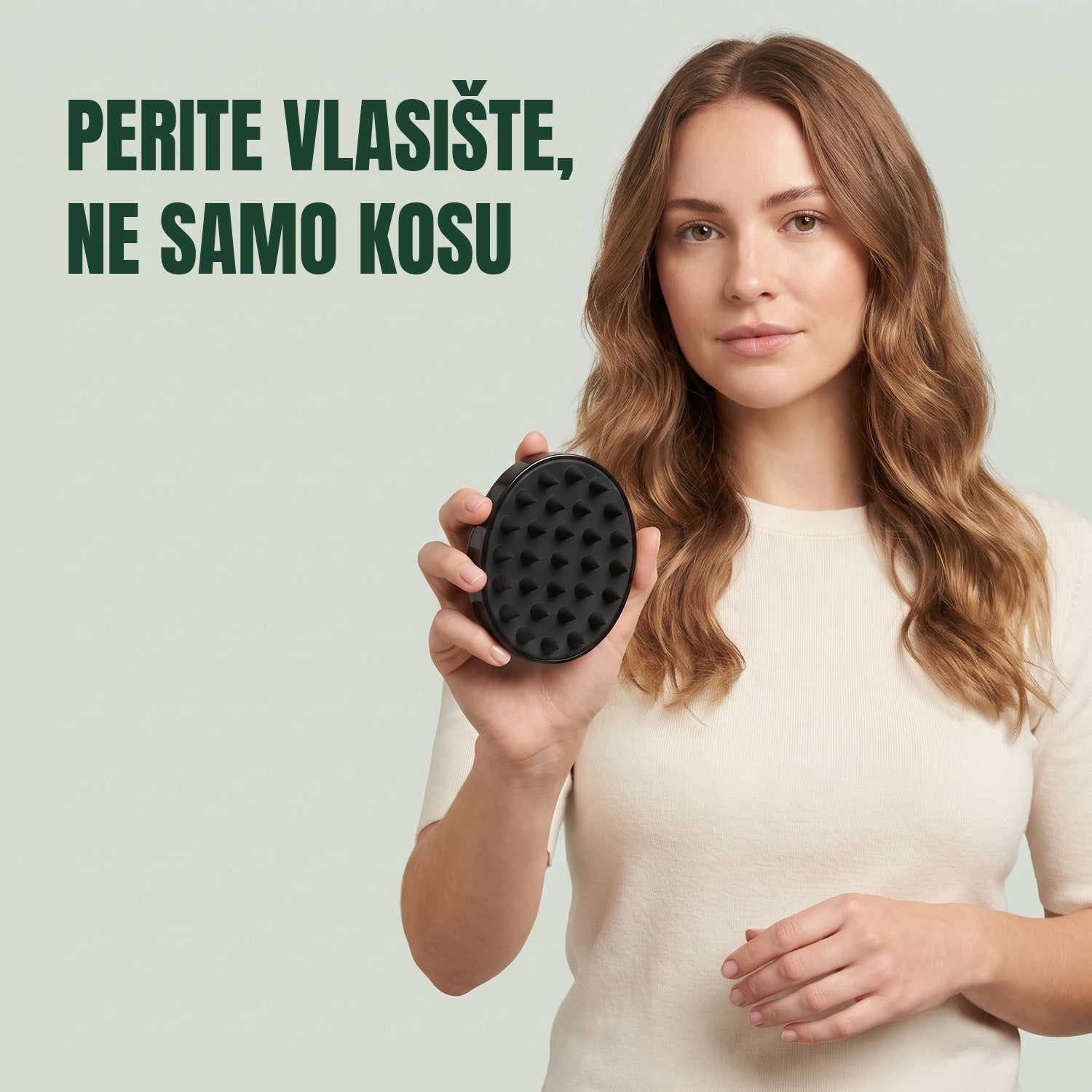 Žena drži četku za masažu vlasišta na zelenoj pozadini