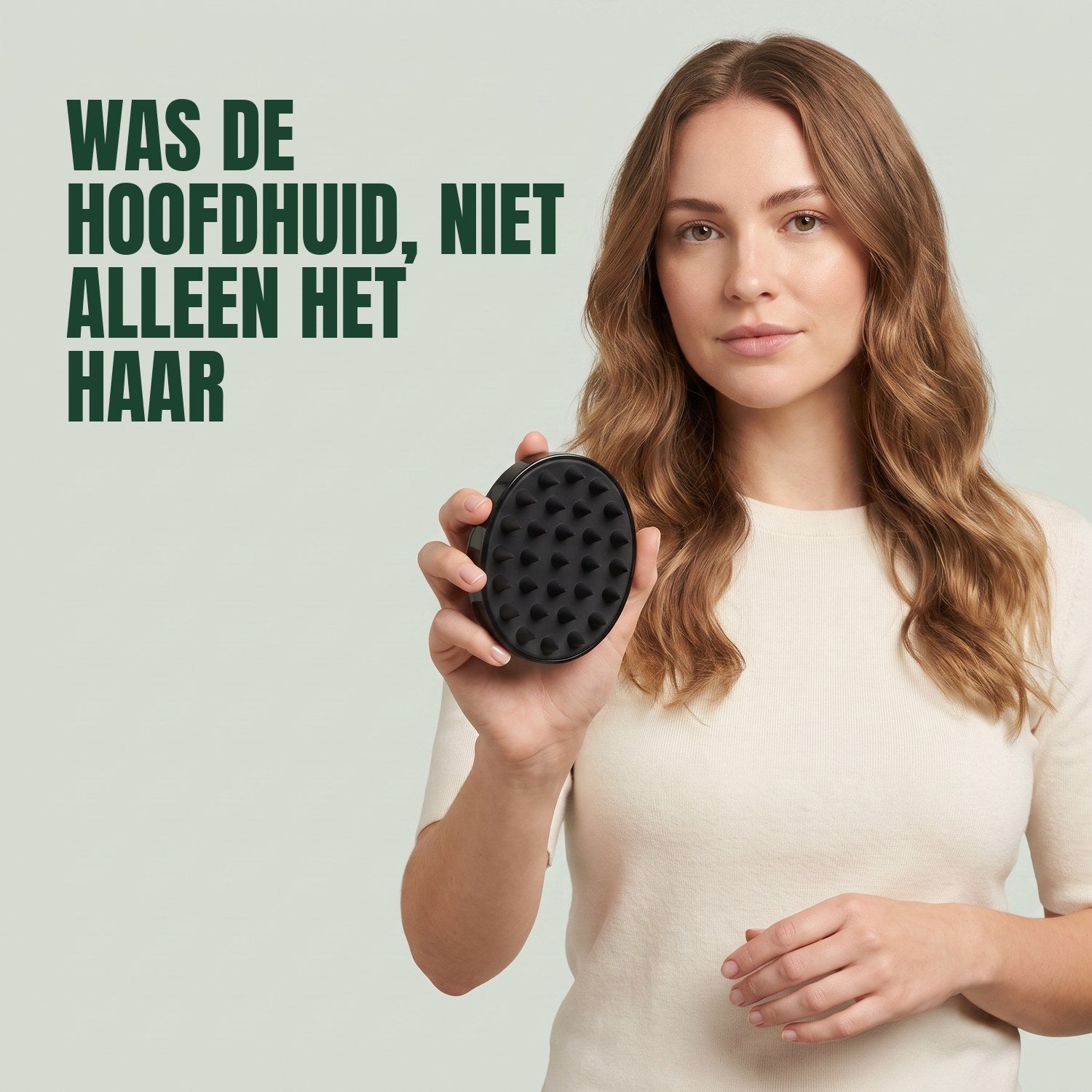 Woman holding the scalp massager brush against a green background