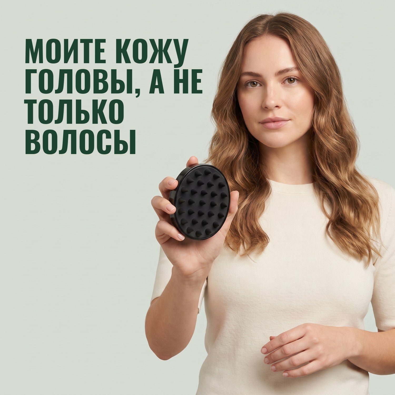 Женщина держит щётку-массажёр для кожи головы на зелёном фоне