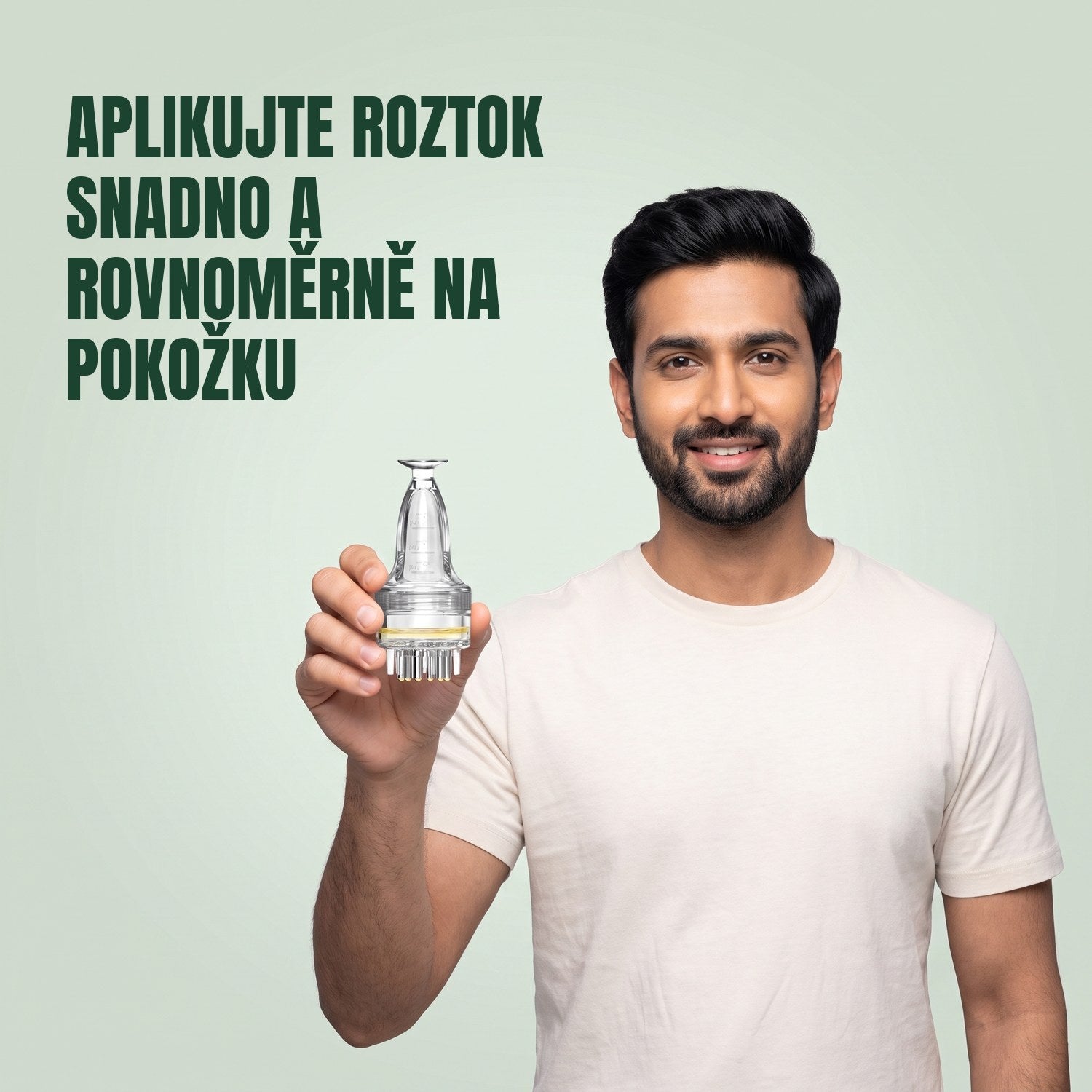 Muž drží základní aplikátor na roztok minoxidilu na zeleném pozadí