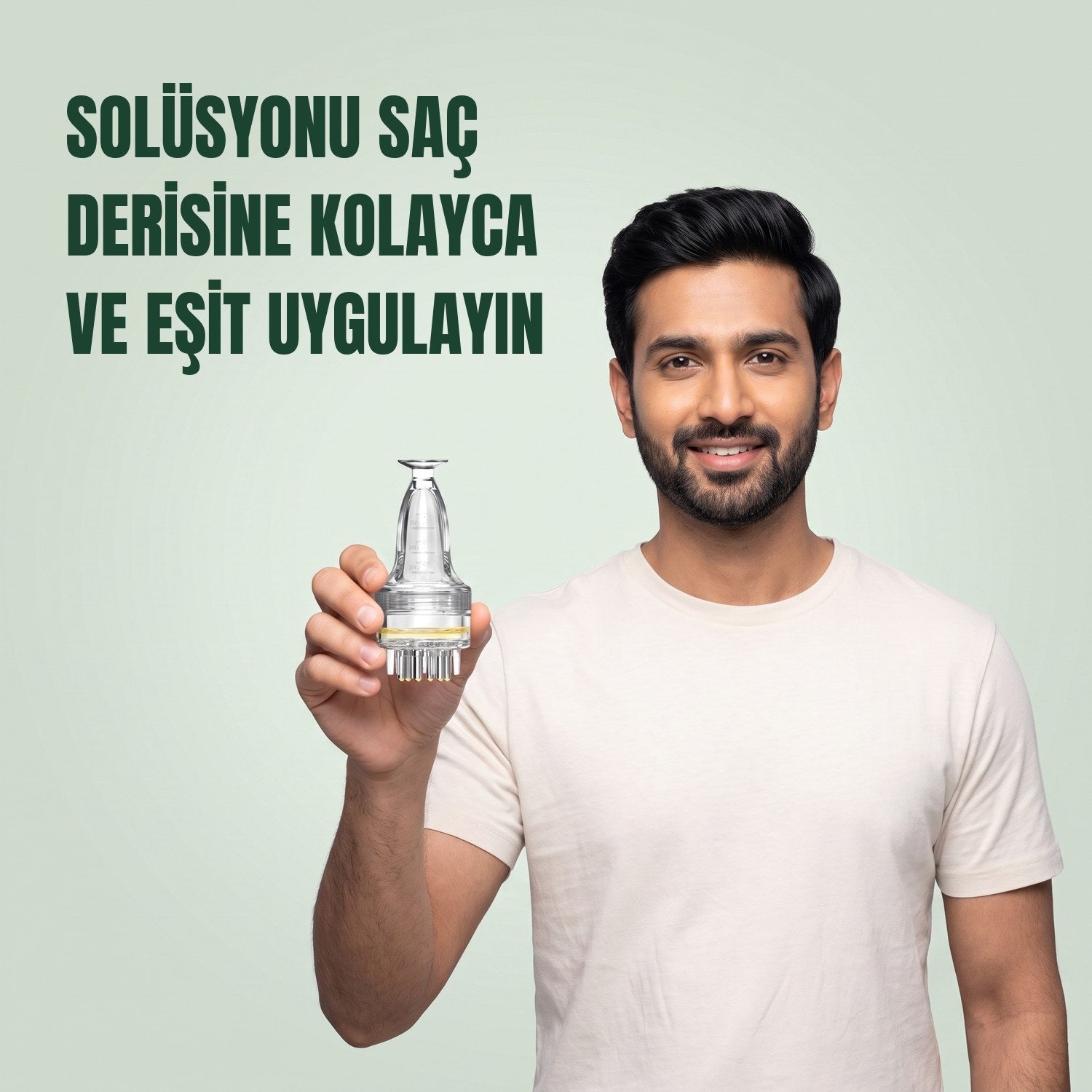 Yeşil arka planda elinde temel minoksidil solüsyon aplikatörü tutan erkek